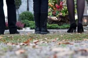 Multigenerational family standing at grave in cemetery
