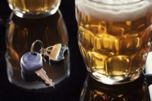 Beer and car key on black table
