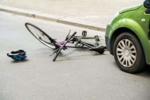 Bicycle hit by green car