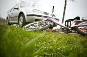 Car parked by wrecked bike
