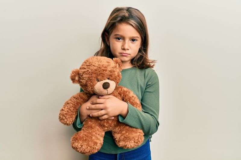 child holding teddy bear